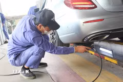 Nhân viên đăng kiểm thực hiện thao tác trong quy trình kiểm định khí thải. (Ảnh: Nguyễn Thắng/TTXVN)