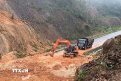 Lực lượng chức năng khẩn trương xử lý các điểm sạt lở trong điều kiện thời tiết có mưa, sương mù. (Ảnh: Cao Nguyên/TTXVN)