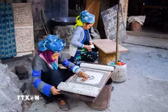 Người phụ nữ Mông tại Lùng Tám thực hiện công đoạn vẽ sáp ong lên vải lanh trước khi nhuộm chàm. (Ảnh: Lan Anh/TTXVN phát)