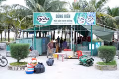 Các hộ kinh doanh thu gom, sắp xếp bàn ghế, thiết bị và vật dụng trước khi vận chuyển khỏi khu vực bãi biển Nhật Lệ. (Ảnh: Tá Chuyên/TTXVN)