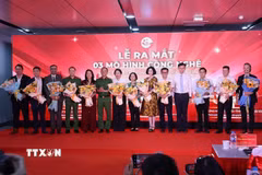 Đại diện lãnh đạo Ủy ban Nhân dân Thành phố Hồ Chí Minh chúc mừng các đơn vị thực hiện 3 mô hình chuyển đổi số phục vụ người dân. (Ảnh: Hồng Đạt/TTXVN)