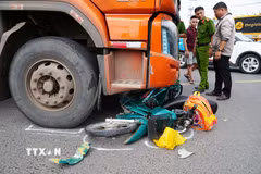 Hiện trường chiếc xe máy nằm chắn ngang phần đầu chiếc xe tải. (Ảnh: Lê Xuân/TTXVN)