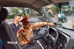 Lực lượng Cảnh sát giao thông kiểm tra thiết bị giám sát hành trình lắp trên phương tiện kinh doanh vận tải. (Ảnh: Trung Nguyên/TTXVN)