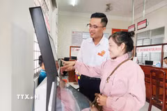 Hướng dẫn người dân thực hiện các thủ tục trên hệ thống điện tử. (Ảnh: Văn Sĩ/TTXVN)