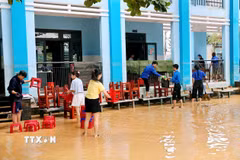 Mặc dù nước chưa rút hết khỏi sân trường nhưng các cô giáo trường Tiểu học Kim Đồng, phường Điện Bàn đã đến trường để dọn dẹp vệ sinh. (Ảnh: Anh Dũng/TXVVN)