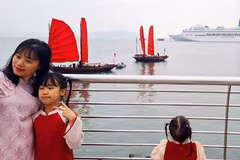 Chụp ảnh cùng thuyền ba vách buồm đỏ truyền thống ven bờ vịnh Hạ Long được nhiều du khách ưa thích.(Nguồn: CTTĐT )
