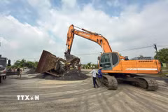 Đội Cảnh sát giao thông đường thủy số 1 phối hợp UBND xã Liên Minh tổ chức rào chắn, ngừng cung cấp điện, nước đối với hai bến vật liệu xây dựng không phép tại Km212+400 và Km213+950 bờ phải sông Hồng. (Ảnh: TTXVN phát)