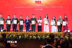 Ban Tổ chức trao giấy chứng nhận và biểu trưng cho các tác giả, nhóm tác giả đạt giải Nhì của Cuộc thi chính luận về bảo vệ nền tảng tư tưởng của Đảng lần thứ 6, năm 2026. (Ảnh: Văn Điệp/TTXVN)