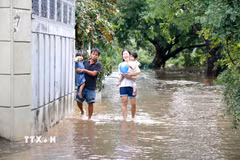 Người dân tại điểm ngập sâu tại phường Bình Thuận (Lâm Đồng) di chuyển đến nơi khác để đảm bảo an toàn. (Ảnh: Nguyễn Thanh/TTXVN)