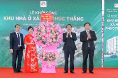 Lãnh đạo tỉnh Vĩnh Phúc tặng hoa cho đại diện Công ty Trách nhiệm Hữu hạn Thương mại và Xây dựng Thân Hà, đơn vị chủ đầu tư Dự án Khu nhà ở xã hội phường Phúc Thắng. (Ảnh: Nguyễn Trọng Lịch/TTXVN)