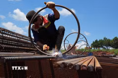 Một công nhân cho biết việc thi công cột khung cốt thép được tăng tốc cả khi trời nắng và trời mưa để đẩy nhanh tiến độ cho công trình. (Ảnh: Nguyễn Dũng/TTXVN)