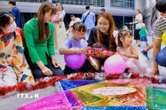 Các em nhỏ được hướng dẫn trang trí cho đèn ông sao tại chương trình vui Tết Trung thu tại Sakai, Osaka. (Ảnh: Nguyễn Tuyến/TTXVN)