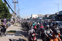 Nhiều người đi xe máy chạy lên vỉa hè để di chuyển khi đường ùn ứ. (Ảnh: Tiến Lực/TTXVN)