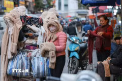 Người lao động, bán hàng trên phố che chắn kỹ chống rét. (Ảnh: Hoàng Hiếu/TTXVN)