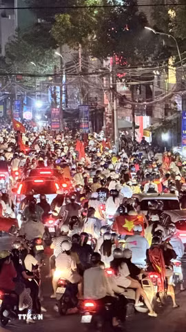 Cơn mưa xuyên suốt cả ngày không ngăn được niềm vui của người hâm mộ Thủ đô. (Ảnh: Minh Quyết/TTXVN)
