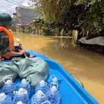 Lực lượng quân đội vận chuyển nước uống tới khu vực bị mưa lũ cô lập. (Ảnh: Quang Duy/TTXVN)