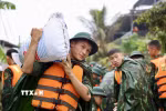 Lực lượng bộ đội hỗ trợ đắp đê bao ngăn nước khu dân cư ven sông Bùi. (Ảnh: Nhật Anh/TTXVN)