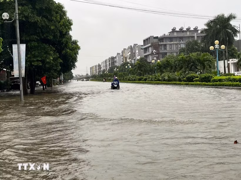 Đường Âu Cơ ngập sâu do mưa lớn kéo dài, phường Hạc Thành, tỉnh Thanh Hóa. (Ảnh: Khiếu Tư/TTXVN)