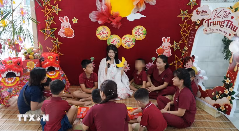 Các em nhỏ được nghe kể chuyện về ngày Tết Trung Thu. (Ảnh: Lê Xuân/TTXVN)