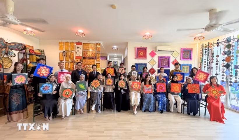 Các sinh viên Đại học Quốc gia Brunei tham gia hoạt động trang trí họa tiết truyền thống của Việt Nam và Brunei Darussalam. (Ảnh: TTXVN phát)