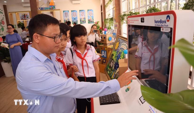 Cán bộ hướng dẫn học sinh trải nghiệm Kiosk dịch vụ công tại không gian đổi mới sáng tạo phường Bình Phước, Đồng Nai, giúp các em tiếp cận phương thức thực hiện thủ tục hành chính trên môi trường số. (Ảnh: Đậu Tất Thành/TTXVN)