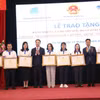 Thứ trưởng Bộ Giáo dục và Đào tạo Lê Quân và Bí thư Trung ương Đoàn Nguyễn Tường Lâm tặng bằng khen cho các giáo viên. (Ảnh: PV/Vietnam+)