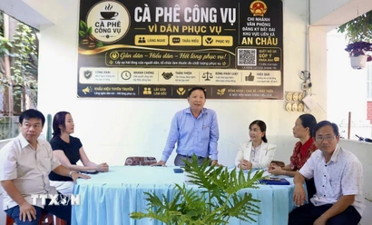 Lãnh đạo Văn phòng Đăng ký đất đai Chi nhánh khu vực liên xã An Châu hướng dẫn người dân hoàn thiện các thủ tục, hồ sơ liên quan đến đất đai tại chương trình. (Ảnh: Thanh Sang/TTXVN)