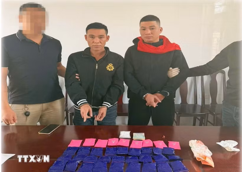Các đối tượng Trần Mạnh Cường và Nguyễn Văn Kiều cùng tang vật thu giữ. (Ảnh TTXVN phát)