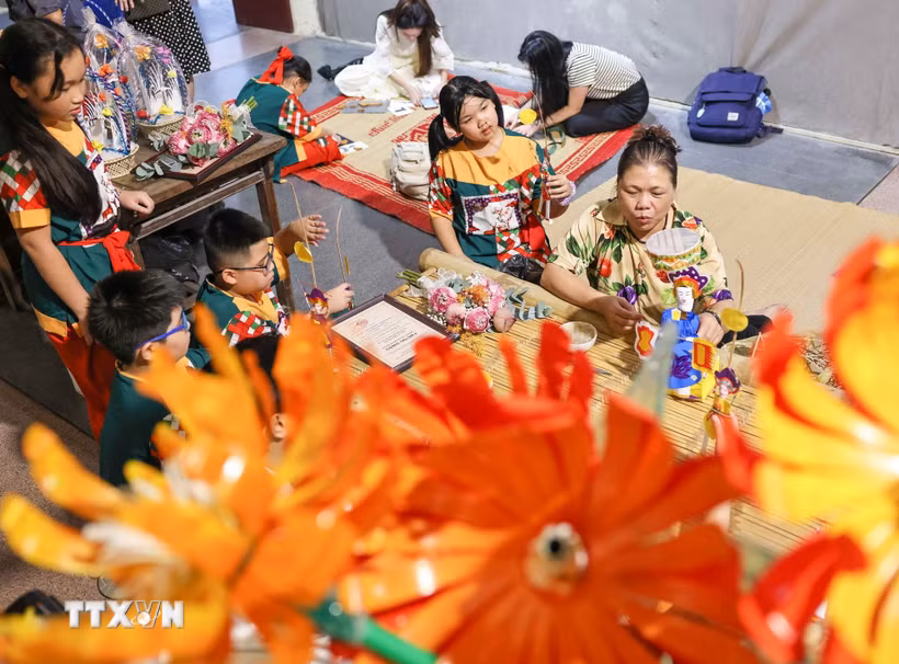 Thiếu nhi trải nghiệm không gian giới thiệu đồ chơi Trung Thu truyền thống, tham gia các hoạt động làm đèn ông sao, đèn kéo quân, tiến sỹ giấy, chuồn chuồn tre. (Ảnh: Thanh Tùng/TTXVN)