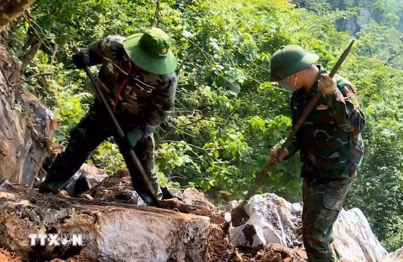 Đội quy tập hài cốt liệt sỹ dùng dụng cụ thô sơ cạy từng tảng đá, tìm kiếm hài cốt liệt sỹ tại Điểm cao 685. (Ảnh: TTXVN phát)