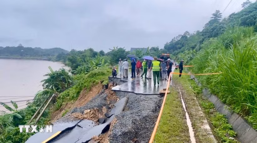 Theo ghi nhận tại hiện trường, toàn bộ phần mặt đường dài khoảng 30 mét đã bị đứt gãy, sạt trượt hoàn toàn xuống phía ta luy âm, giáp bờ sông Hồng. (Ảnh: TTXVN phát)