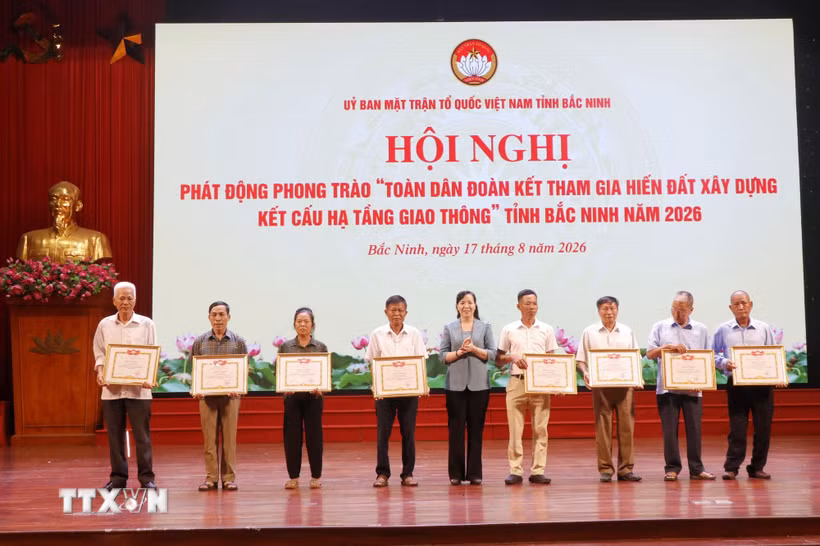 Khen thưởng các hộ gia đình tiêu biểu có nhiều thành tích trong hiến đất làm đường. (Ảnh: Thanh Thương/TTXVN)