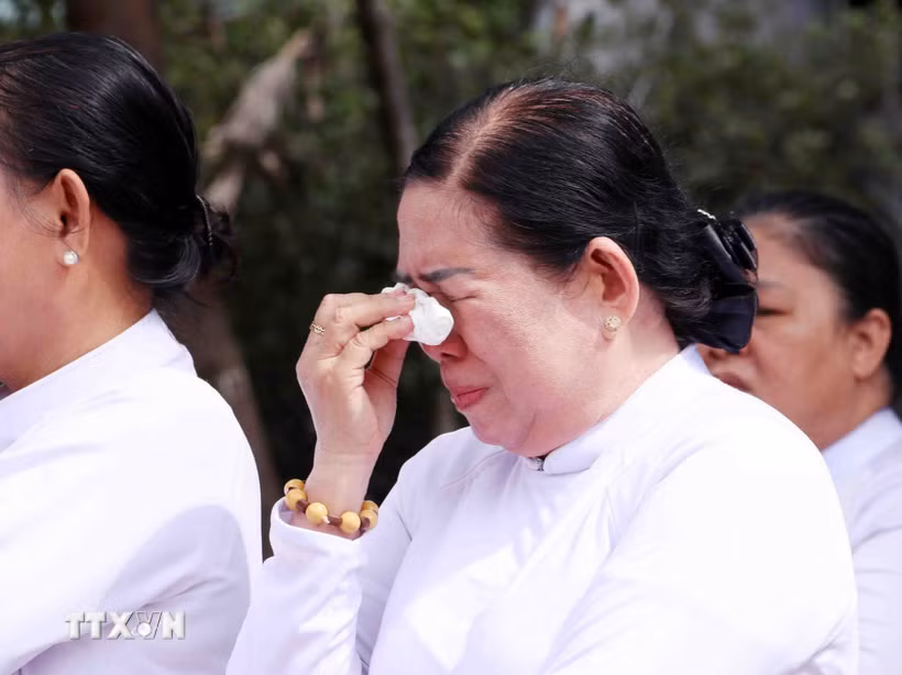 Nỗi xúc động của các tín hữu đạo Cao Đài trước anh linh các anh hùng liệt sỹ được quy tập tại Công viên Lê Thị Riêng. (Ảnh: Xuân Khu/TTXVN)