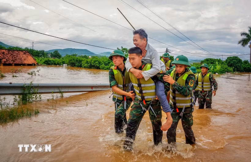 Cán bộ chiến sỹ Sư đoàn 325 hỗ trợ người dân trên địa bàn xã Nam Dương di dời. (Ảnh: Danh Lam/TTXVN)