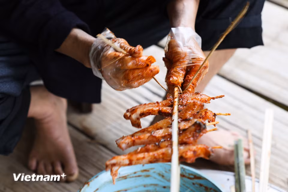 Cá được làm sạch, tẩm ướp kỹ, kẹp vào thanh tre và nướng đều hai mặt. Món ăn thường xuất hiện trong lễ hội, cưới hỏi hay dịp mừng cơm mới – biểu tượng của sự sung túc, đoàn viên. (Ảnh: PV/Vietnam+)