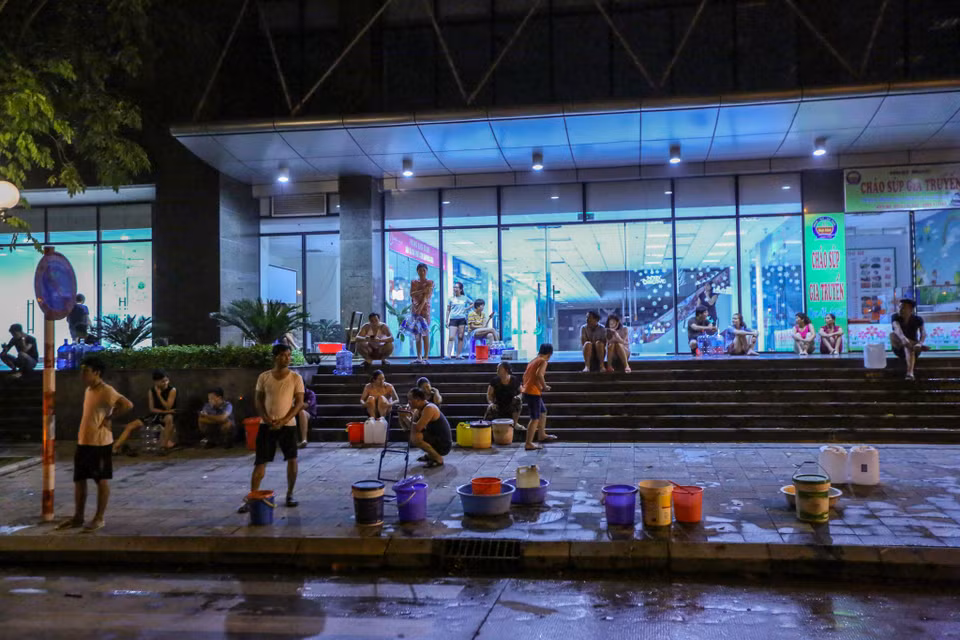 Ngay trong đêm 16 rạng sáng 17/10, hàng trăm hộ dân tại tòa nhà Gemek Tower (Hoài Đức, Hà Nội) đã mang theo xô, chậu tấp nập xếp hàng, chờ đến lượt nhận nước sạch về sinh hoạt. (Ảnh: Minh Sơn/Vietnam+)