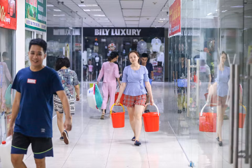 Thời điểm 12h đêm nhưng cả tòa chung cư vẫn tấp nập người dân tranh thủ đi lấy nước. (Ảnh: Minh Sơn/Vietnam+)