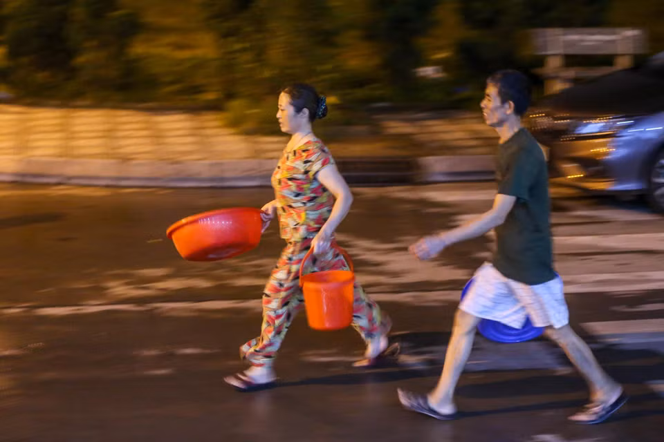 Nhiều người tỏ ra vội vã đến lấy nước vì chỉ có 1 xe téc mà lại phục vụ cho nhu cầu rất lớn của cư dân. (Ảnh: Minh Sơn/Vietnam+)