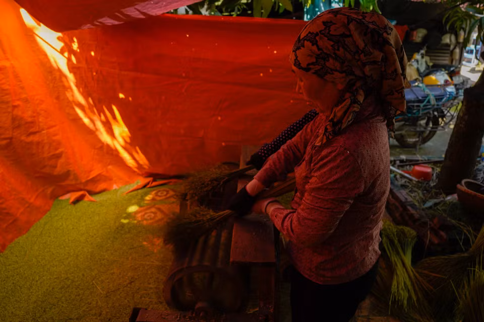 Với người làm cốm, khâu quan trọng nhất là khi rang phải đều lửa. (Ảnh: PV/Vietnam+)