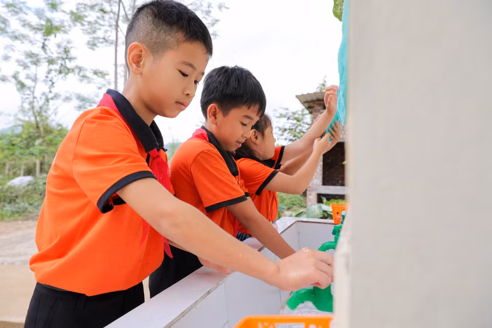 Các em học sinh trường Tiểu học Thành Long (xã Thành Long, huyện Hàm Yên, Tuyên Quang) hào hứng sử dụng nhà vệ sinh mới. (Ảnh: Minh Sơn/Vietnam+)