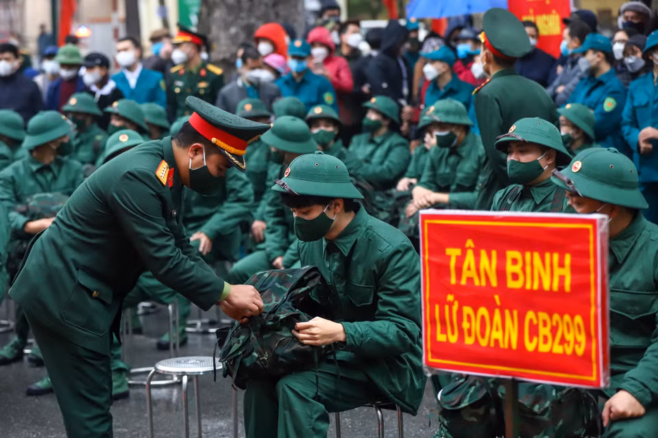 Một tân binh được chỉ huy hỗ trợ sửa soạn lại balo trước khi lên đường. (Ảnh: Minh Sơn/Vietnam+)