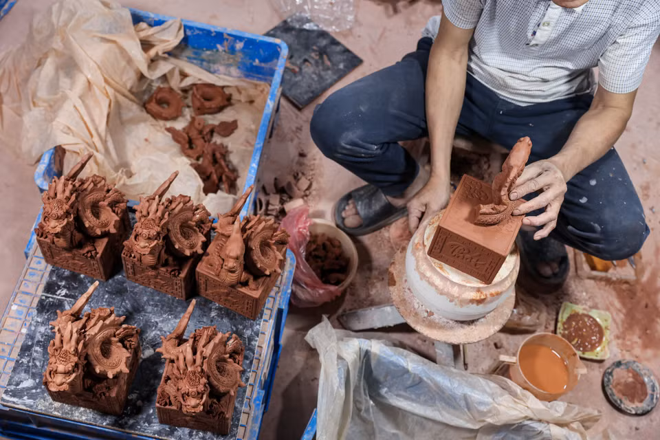 Ông Khoa chia sẻ để hoàn thiện một sản phẩm rồng bằng gốm sứ phải trải qua nhiều công đoạn tỉ mỉ. Dịp cận Tết, ông cùng các đồng nghiệp có thể làm đến 12 tiếng/ngày để kịp tiến độ. (Ảnh: Minh Sơn/Vietnam+)