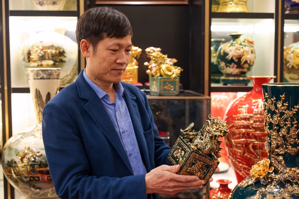 Ông Lực cho biết năm nay doanh nghiệp không sản xuất những bộ sưu tập màu sắc sặc sỡ hay dát vàng toàn bộ sản phẩm. Thay vào đó, các sản phẩm được chủ yếu tập trung vào màu trầm như đen và xanh,...với những đường nét mạ vàng sang trọng. (Ảnh: Minh Sơn/Vietnam+)