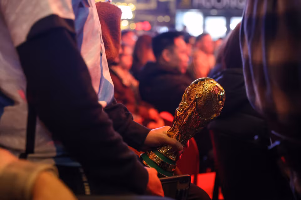 Một cổ động viên mang theo mô hình chiếc cup vàng của bóng đá thế giới đi cổ vũ. (Ảnh: Minh Sơn/Vietnam+)