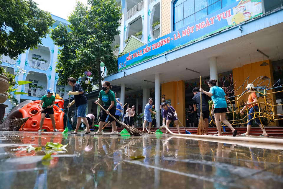Bà Trần Thị Liên - Hiệu trưởng trường mần non Tứ Liên chia sẻ: "Trước tình hình lũ gây ngập úng, nhà trường thường xuyên theo dõi mực nước, chỉ cần nước rút xuống là lập tức huy động cán bộ nhân viên dọn vệ sinh. Ngay từ chiều qua chúng tôi đã bắt đầu vệ sinh ở khu vực tầng 1, ngày hôm nay nước tiếp tục rút ra khỏi sân trường chúng tôi cũng nhanh chóng dọn hết khu vực sân trường." (Ảnh: Minh Sơn/Vietnam+)