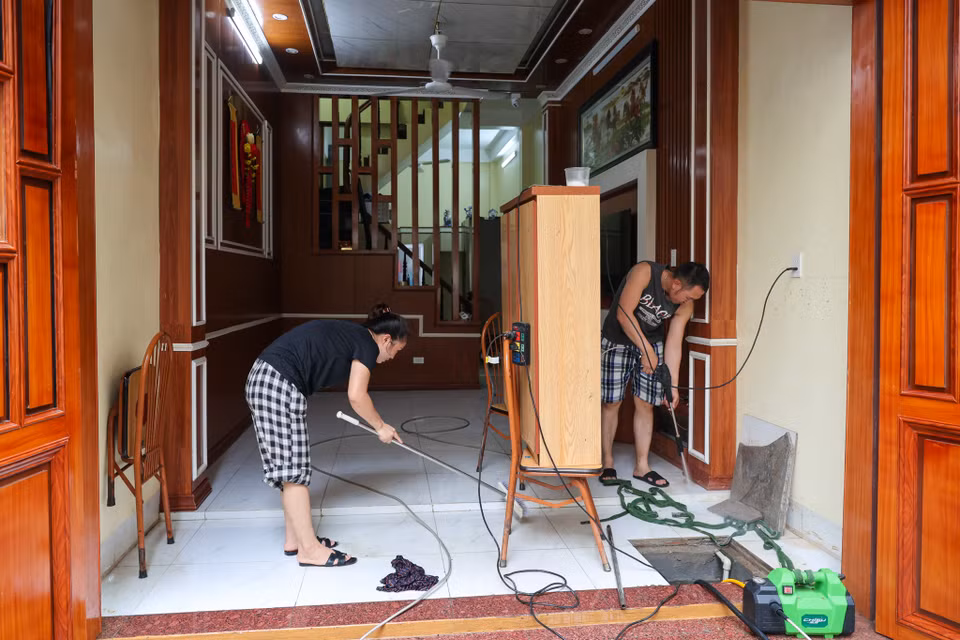 Một cư dân Tứ Liên chia sẻ: "Nhà tôi bị ngập gần đến nửa tường, tất cả đồ đạc ở tầng trệt đều bị ướt sũng. Chúng tôi chỉ mong mọi thứ sớm trở lại bình thường." (Ảnh: Minh Sơn/Vietnam+)