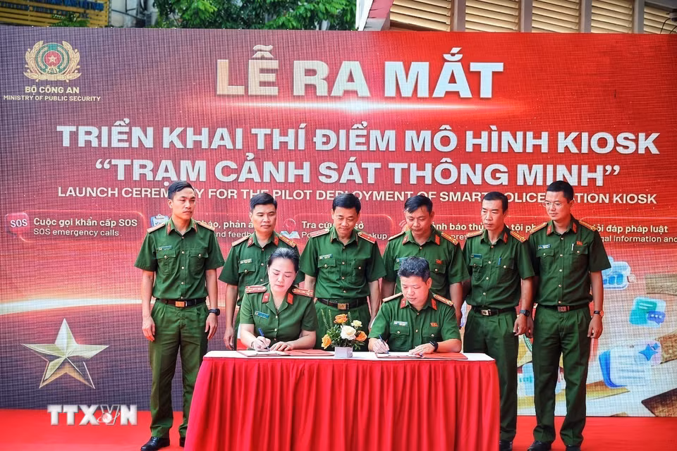 Đại diện các đơn vị ký kết phối hợp triển khai thí điểm mô hình Kiosk “Trạm Cảnh sát thông minh”. (Ảnh: Phạm Tuấn Anh/TTXVN)