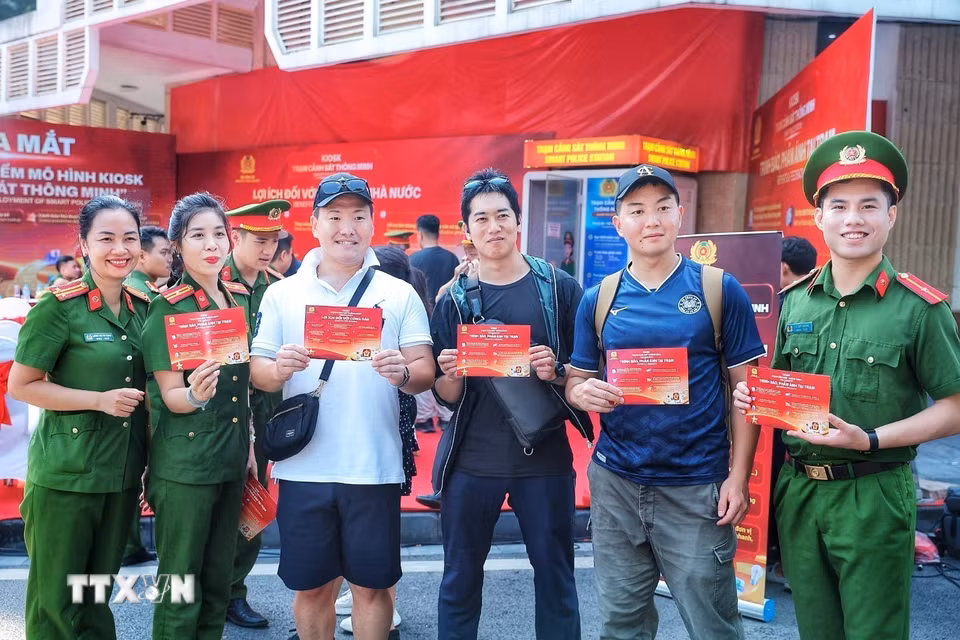 Cán bộ Công an Việt Nam và cảnh sát Nhật Bản chụp ảnh lưu niệm tại khu vực triển khai thí điểm mô hình Kiosk “Trạm Cảnh sát thông minh”. (Ảnh: Phạm Tuấn Anh/TTXVN)