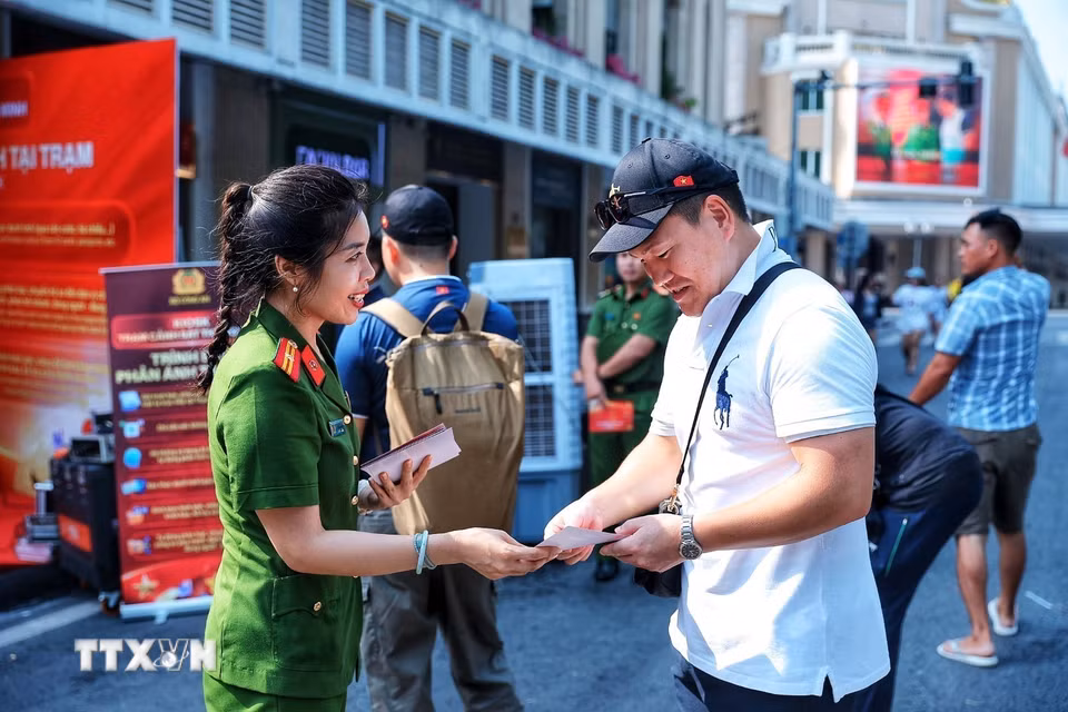 Cán bộ Công an giới thiệu, hướng dẫn người dân tìm hiểu các tiện ích của mô hình Kiosk “Trạm Cảnh sát thông minh”. (Ảnh: Phạm Tuấn Anh/TTXVN)