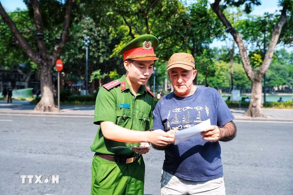 Cán bộ Công an giới thiệu cho một du khách nước ngoài tìm hiểu thông tin về Kiosk “Trạm Cảnh sát thông minh”, góp phần giúp người nước ngoài tiếp cận thuận tiện hơn với các dịch vụ hỗ trợ của lực lượng Công an. (Ảnh: Phạm Tuấn Anh/TTXVN)